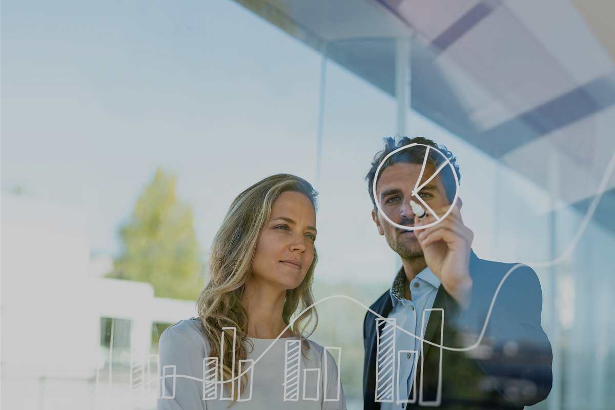 Symbolbild: Geschäftsmann und Geschäftsfrau zeichnen Chart auf Glasscheibe