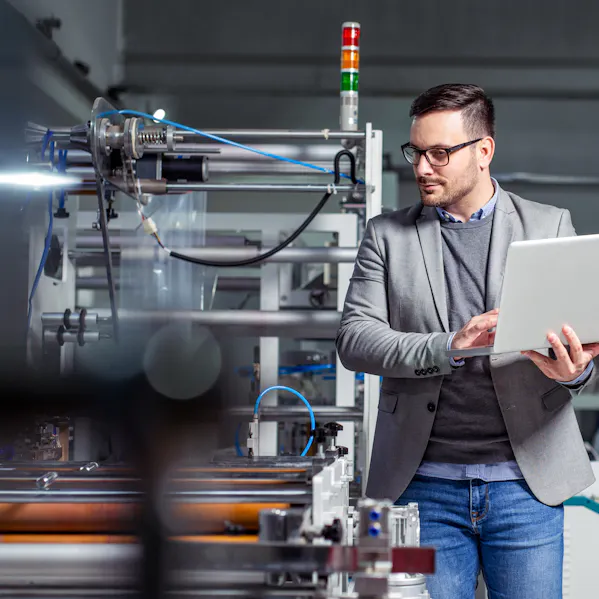 Man with laptop at a production line