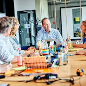 Allfoye Kolleg:innen sitzen gemeinsam am Tisch.