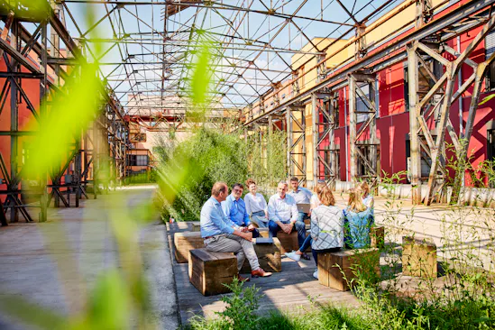 Kollegen sitzen draußen und unterhalten sich.