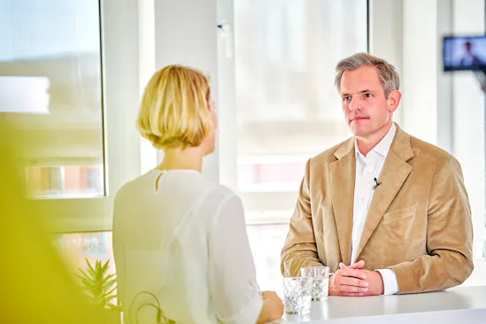 Eine Frau und ein Mann stehen sich gegenüber und sprechen über Führungskräfteentwicklung