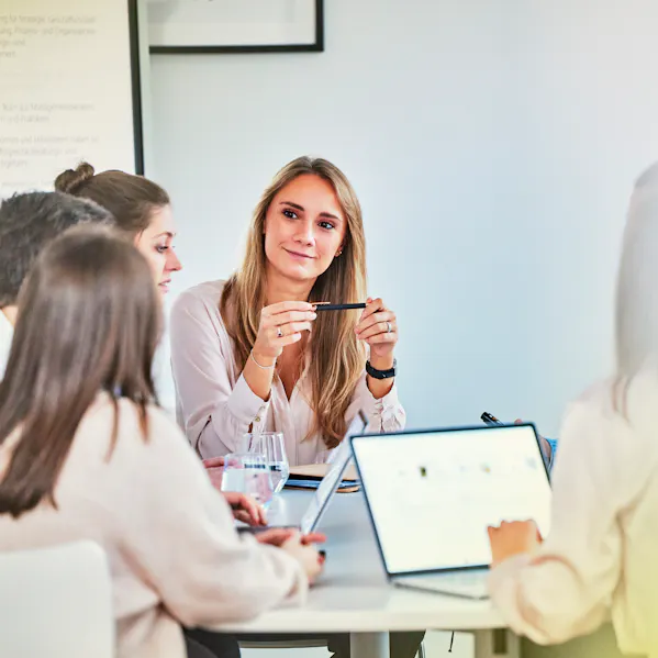 Einige Personen sitzen zusammen an einem Tisch und sprechen über Unternehmenskultur und Purpose