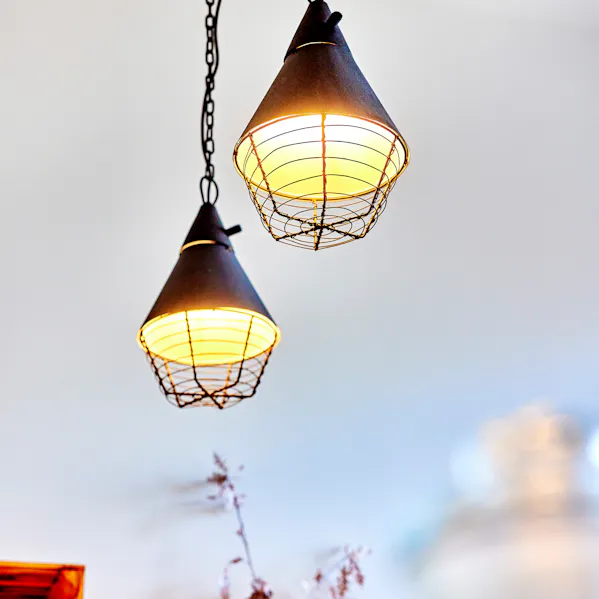 Drei Lampen hängen an der Decke und bringen Licht ins Dunkel